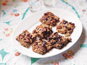 Cranberry, pecan and maple syrup flapjacks on plate