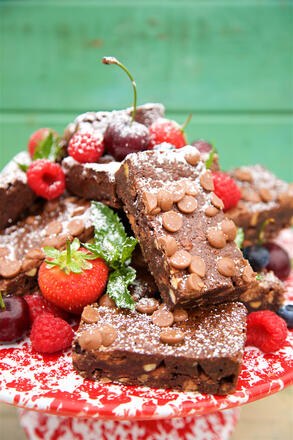 Stack of brownies decorated with flowers and strawberries