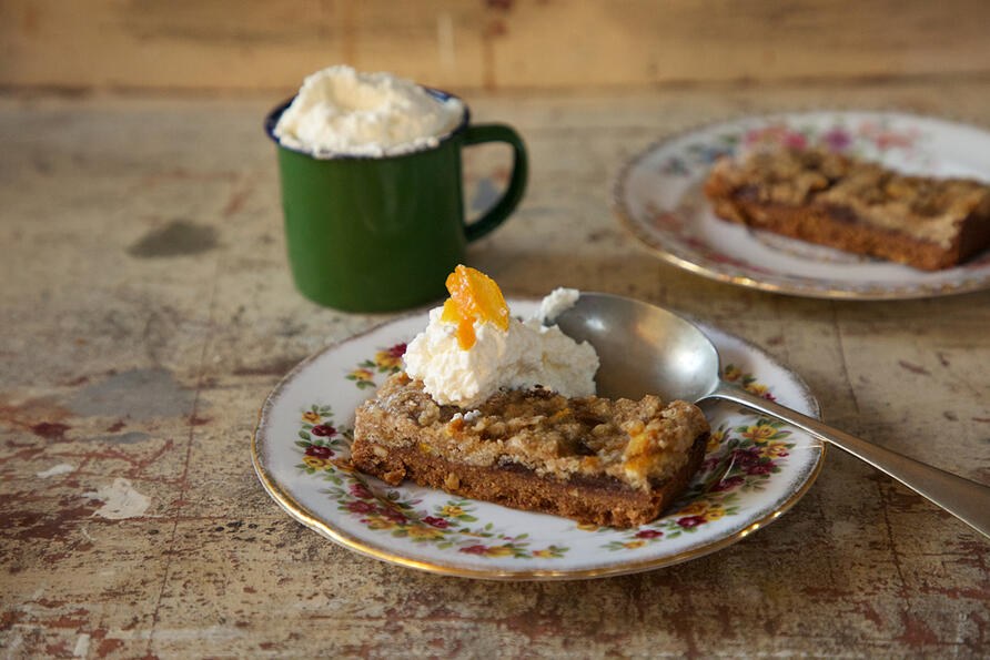 Mincemeat Cake slice on plate with cream and spoon served as a pudding